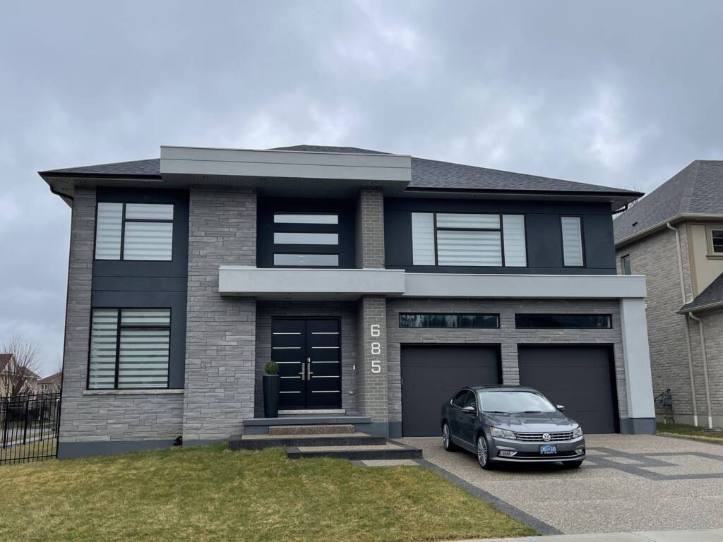 Front view of a modern home in Kitchener featuring large American-style windows and sleek curb appeal.