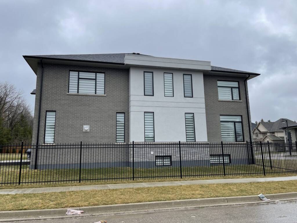 Back view of a modern grey brick home in Kitchener showing windows that may need replacement
